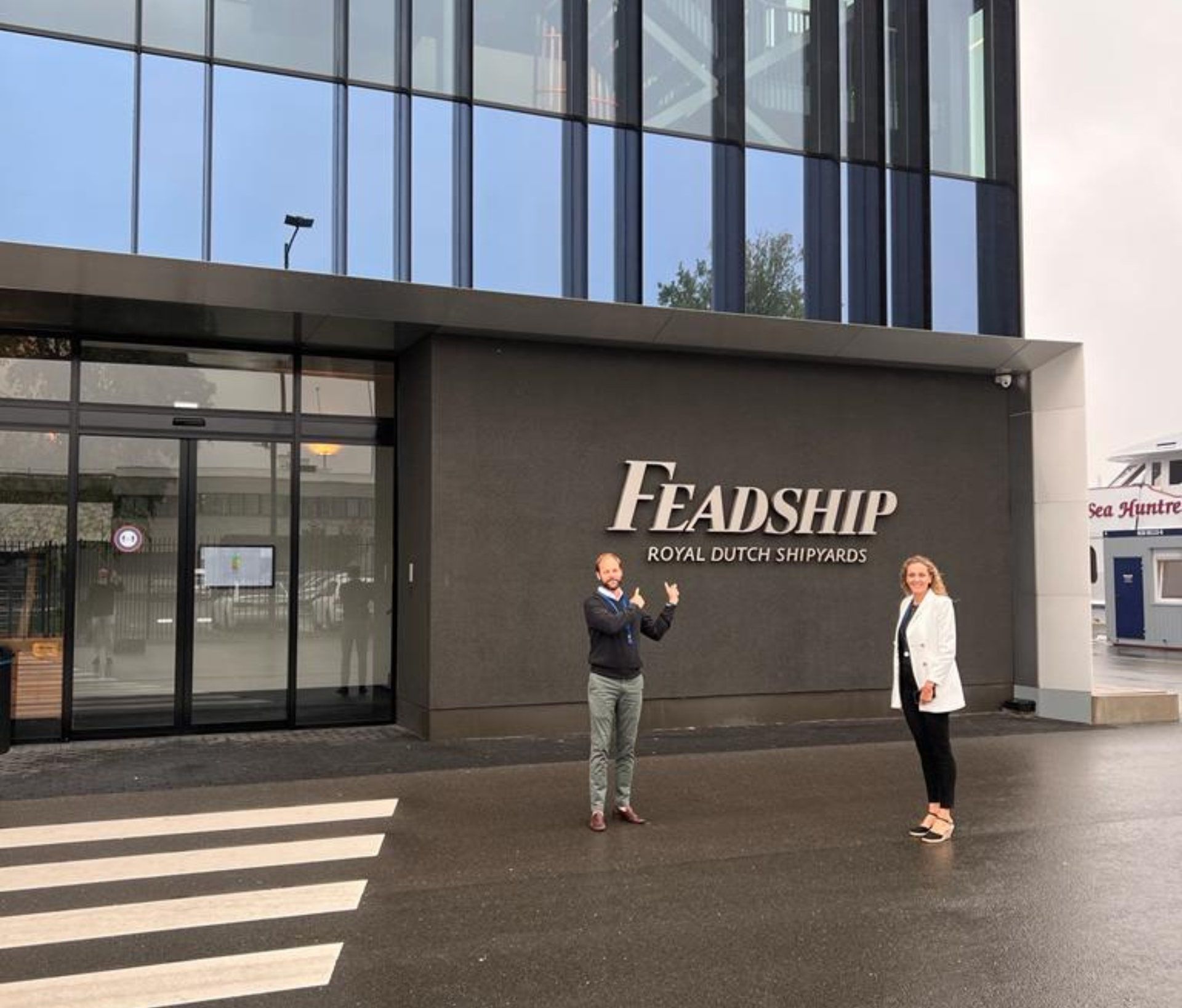 Two people standing in front of a building that says leadership in one of the Caribbean yacht charter destinations.